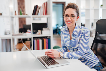 portrait of a beautiful female administrative assistant at workplace.