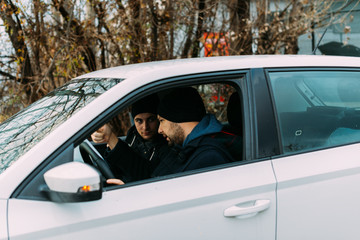 Two Thieves parked in an ally waiting while talking on the phone, observing their target and loading their guns.