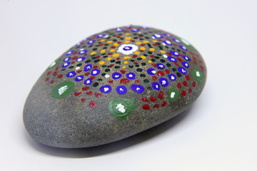 closeup of a uniquely painted grey stone on white background