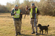 © Mountains Hunter - Hunter with a gun and a dog go on the first snow in the steppe, Hunting pheasant in a reflective vest