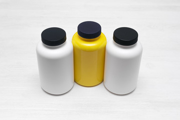 Sport nutrition jars on a white wooden table background.