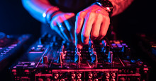 Close Up Of DJ Hands Controlling A Music Table In A Night Club.