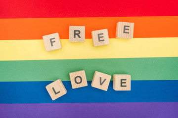 Wall Mural - top view of free love lettering made of  wooden cubes on paper rainbow background
