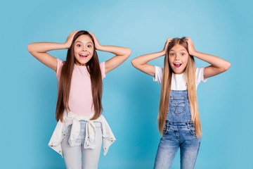 Canvas Print - Portrait of two people nice cute amazed attractive charming cheerful funny straight-haired pre-teen girls touching head great news wow cool isolated over blue pastel background