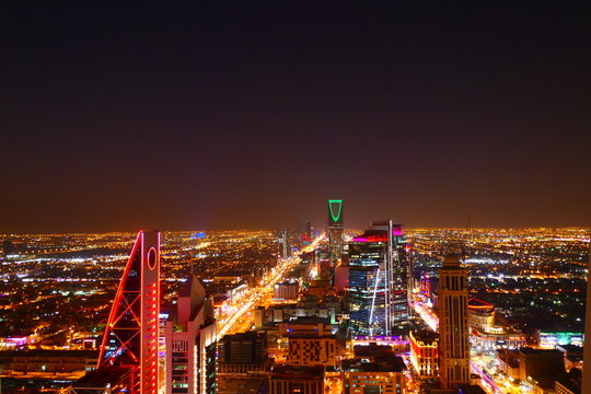 Panorama view to the skyline of Riyadh by night, with skyscrapers in the background and busy traffic on the streets of Riyadh, the capital of Saudi Arabia