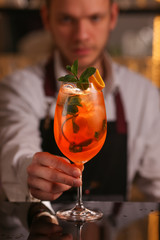 Wall Mural - Barmen is making Aperol Spritz cocktail.  Alcohol cocktail on black background surface