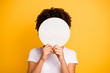 Close up photo beautiful amazing she her dark skin lady hiding face round circle banner placard do not want be recognized wear casual white t-shirt isolated yellow bright vibrant vivid background