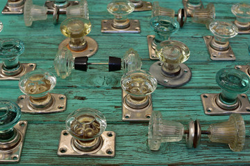 Wall Mural - collection of vintage glass door handles on an old wooden turquoise table, details