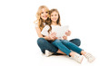 © LIGHTFIELD STUDIOS - pretty woman and cute child using laptop while sitting on floor and looking at camera on white background