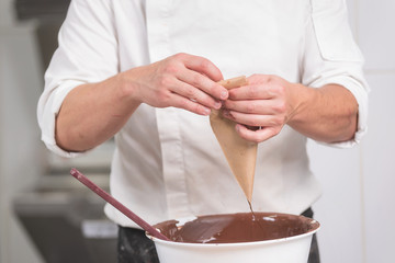 Wall Mural - Professional confectioner making chocolate sweets at confectionery shop .