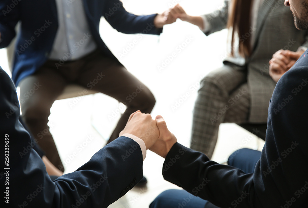 Group of people praying before meeting in office