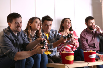 Wall Mural - Group of friends eating nuggets while playing video game at home