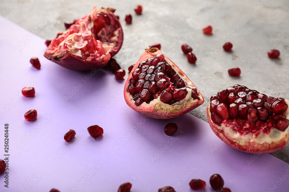 Pieces of ripe pomegranate on color background
