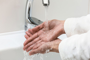  Woman washing hands in sink