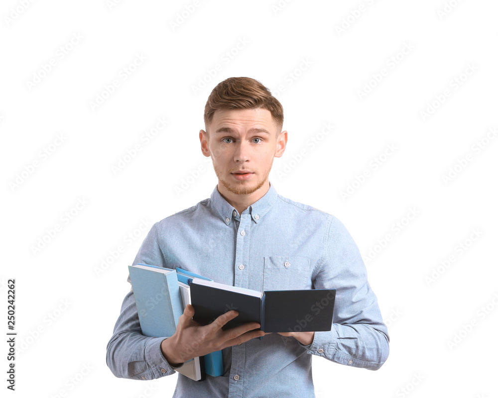 Handsome young man with books on white background
