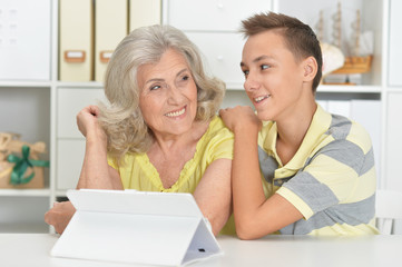 Canvas Print - Portrait of grandson and grandmother using tablert