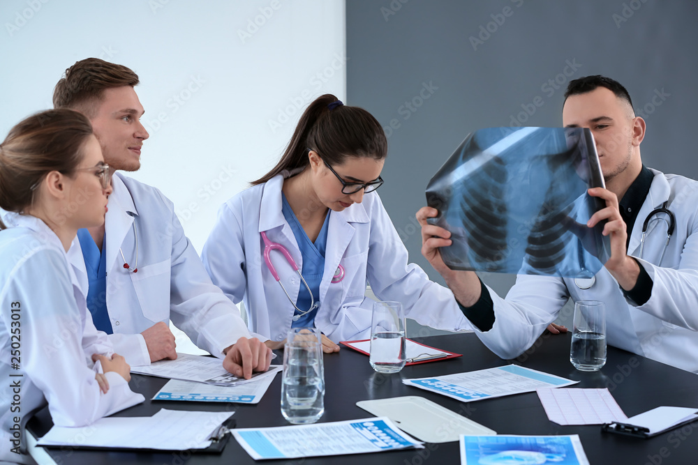 Team of doctors discussing diagnosis at table in clinic