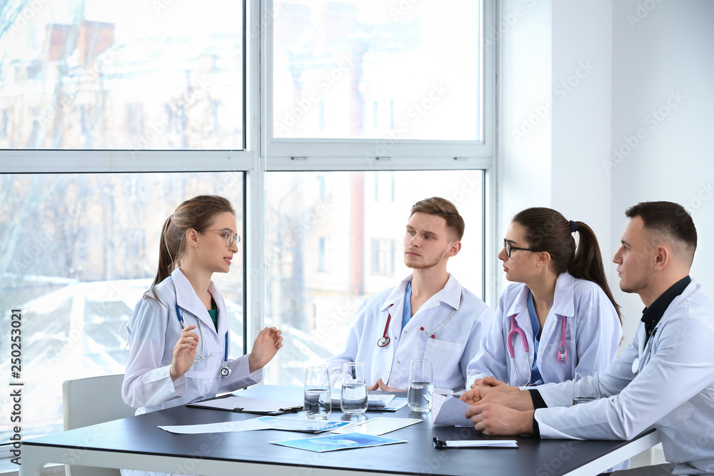 Team of doctors discussing diagnosis at table in clinic
