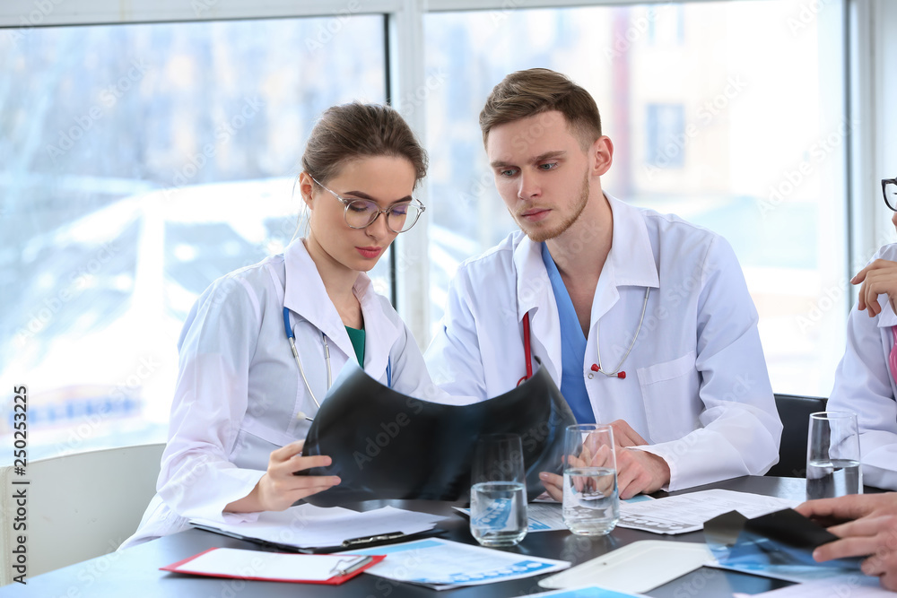 Team of doctors discussing diagnosis at table in clinic