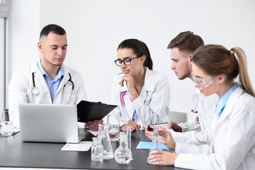 Canvas Print - Interns conducting experiment with flasks in clinic