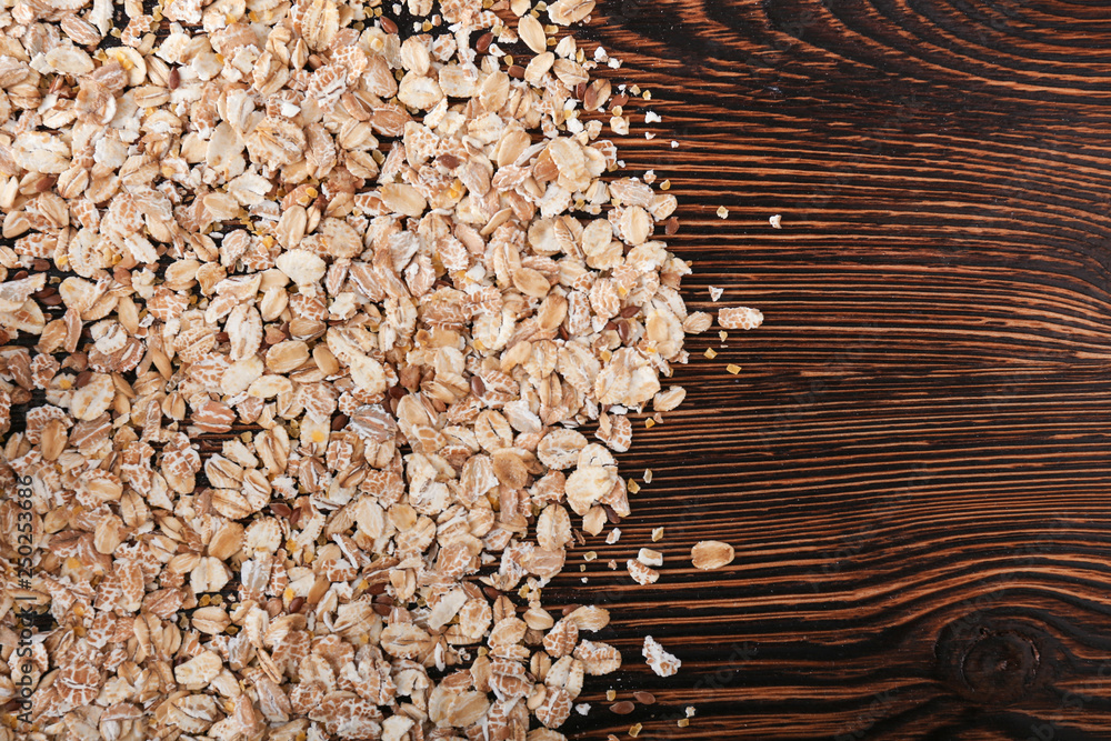 Heap of oat flakes on wooden background