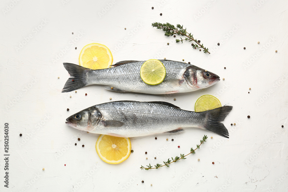 Tasty fresh seabass fish with spices on white background - obrazy, fototapety, plakaty 