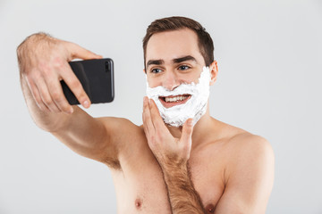 Wall Mural - Portrait of a cheerful shirtless bearded man standing