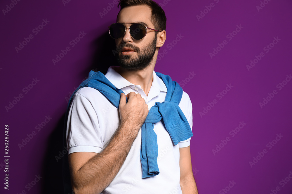 Handsome fashionable man on color background