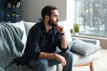 Canvas Print - handsome fashionable man sitting on sofa at home