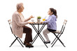 © Ljupco Smokovski - A Full length profile shot of a senior woman sitting at a table with coffee and talking to her granddaughter isolated on white background