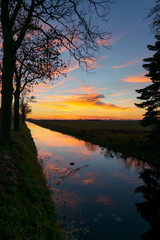 Sticker - Beautiful sunset over the dutch landscape near Gouda, Netherlands. The colorful clouds are reflected in the water of the canal.