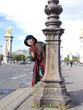 femme envoyant un bisou devant le Pont Alexandre 3, Paris