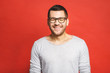 © denis_vermenko - Charming handsome. Handsome cheerful young man in casual wear smiling while standing isolated on red background.