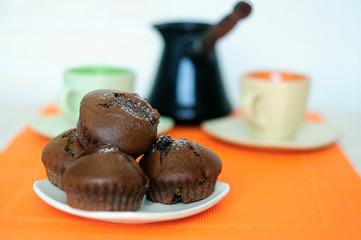 Chocolate muffins two cups and turk with coffee.