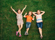 © annanahabed - Happy children having fun outdoors. Kids playing in summer park. Little boy and two girls lying on green fresh grass