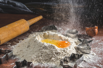 Flour and eggs on rustic wooden background