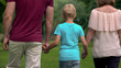 Family with kid holding hands, walking away, togetherness and family support