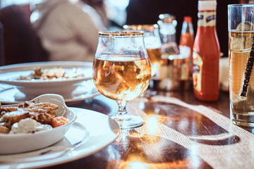 Young friends dine in the cafe outdoors. Close-up image of a table with different dishes and drinks