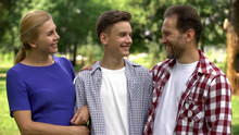 Happy Parents Looking At Teenage Son With Pride, Successful College Student