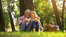 Loving Old Couple Hugging In Park And Eating Green Apples, Picnic Family Weekend