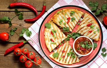 Wall Mural - Quesadilla grill with spicy salsa with chili pepper. Mexican traditional food, wheat tortillas. top view. 