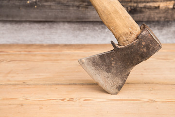 Old ax with a wooden handle stuck in wooden log. Concept for woodworking or deforestation. Selective focus.