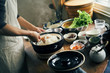 © hideo tsuto - 土鍋で炊いたご飯をかき混ぜる女性