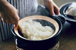 © hideo tsuto - 土鍋で炊いたご飯をかき混ぜる女性