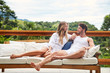 © sanneberg - Loving couple in morning relaxing on balcony sofa