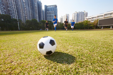 asian soccer football players chasing the ball