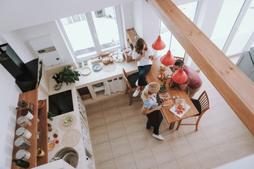 Wall Mural - Loving mother cooking dinner and spending time with her family