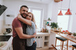 © Yakobchuk Olena - Beautiful blond lady embracing her husband in kitchen
