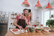 © Yakobchuk Olena - Cheerful blond lady hugging her husband from behind while he cooking dinner