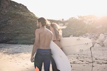 Caucasian Man And Woman Going Surfing At The Beach